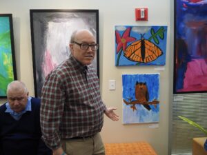 John Orr stands in front of a painting at the JCC